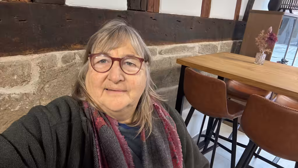 Frau vor Backsteinmauer in Cafe