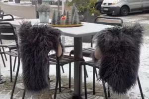 Zwei leere Stühle an einem Café-Tisch im Winter