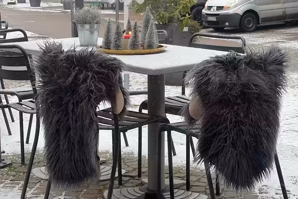 Zwei leere Stühle an einem Café-Tisch im Winter
