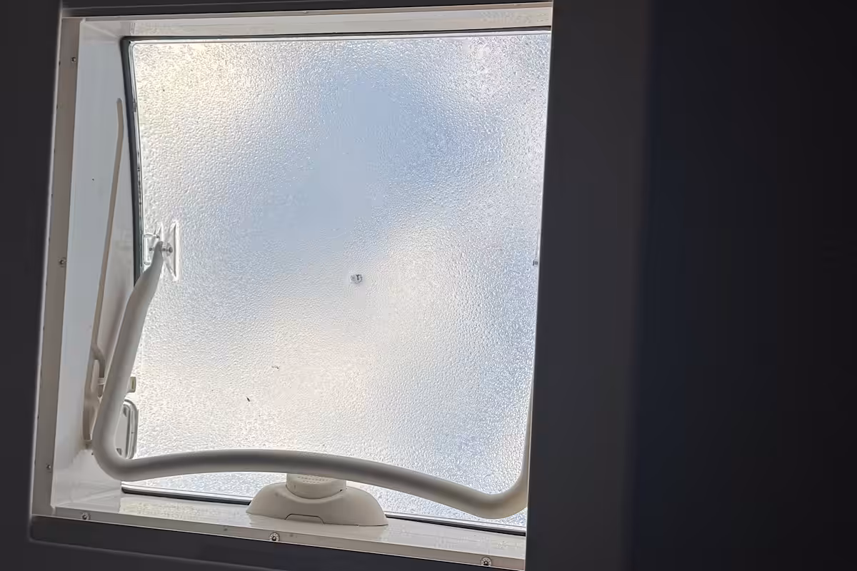 Blick durch die Dachluke eines Wohnmobils nach draußen
