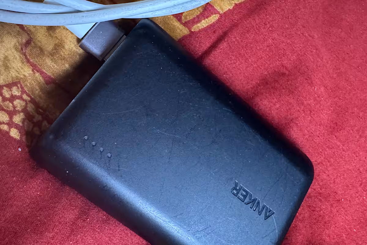 Anker-Powerbank mit Ladekabel auf einer roten Decke